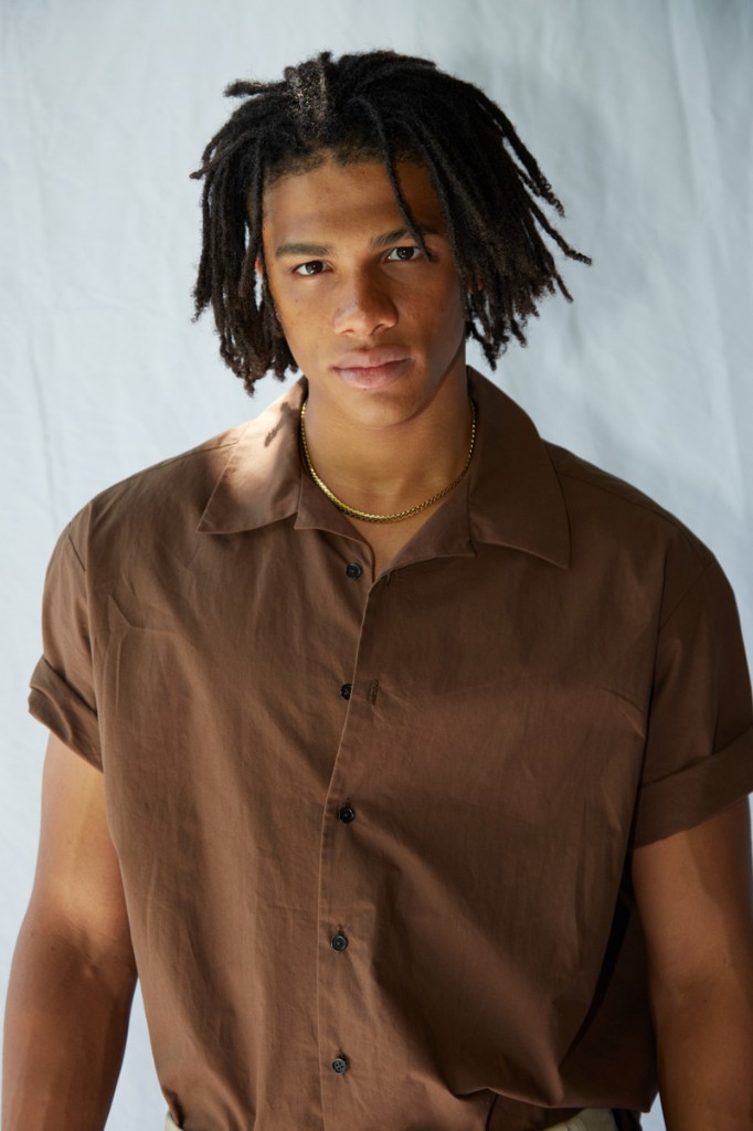 Professional portrait of Nnamdi Unamadu in a brown shirt against a light backdrop